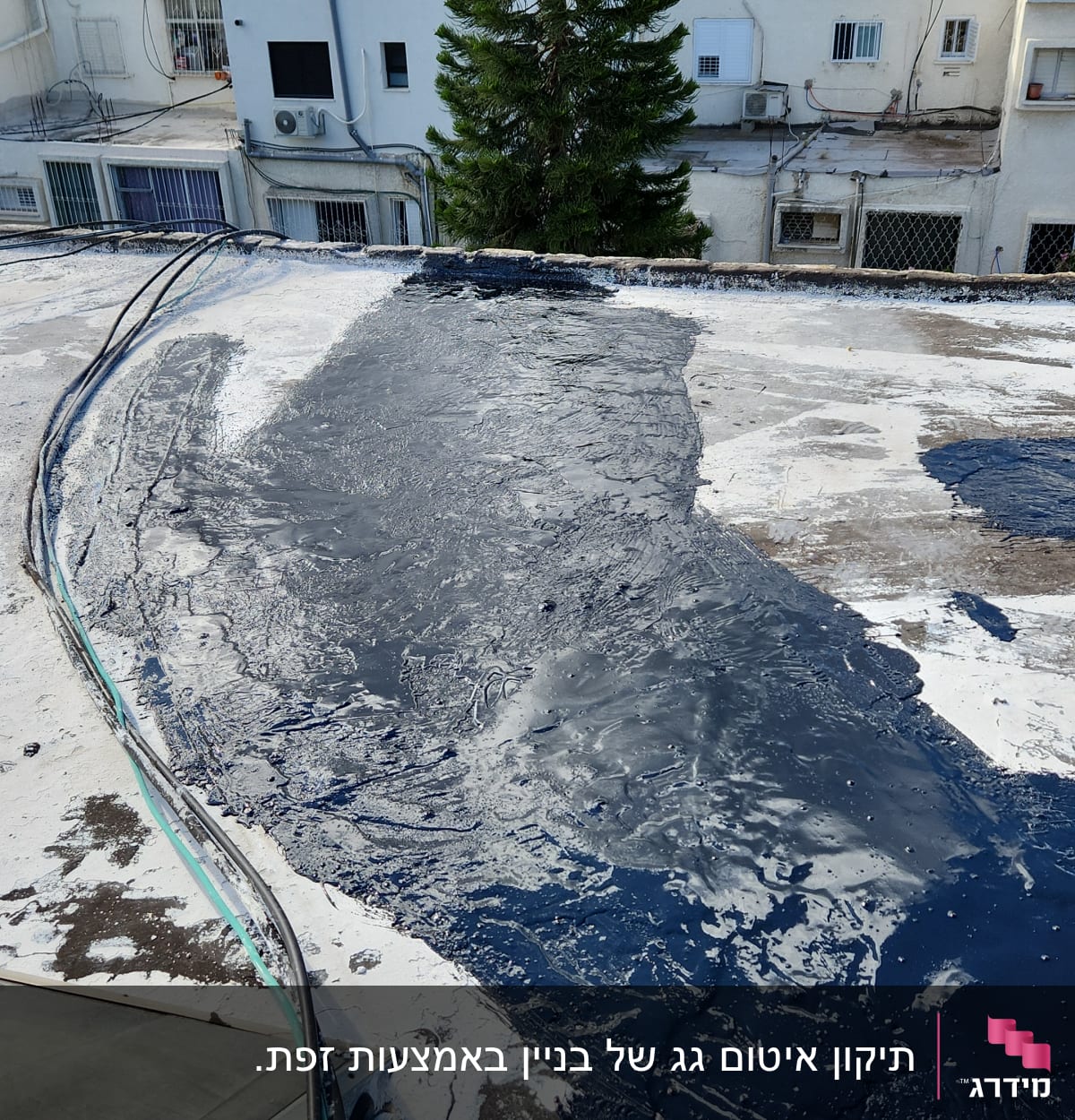 גג עם חומר איטום כהה, כבלים מונחים בצד